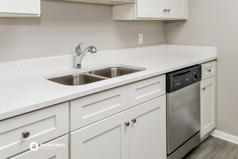 a kitchen with white cabinets and a stainless steel sink