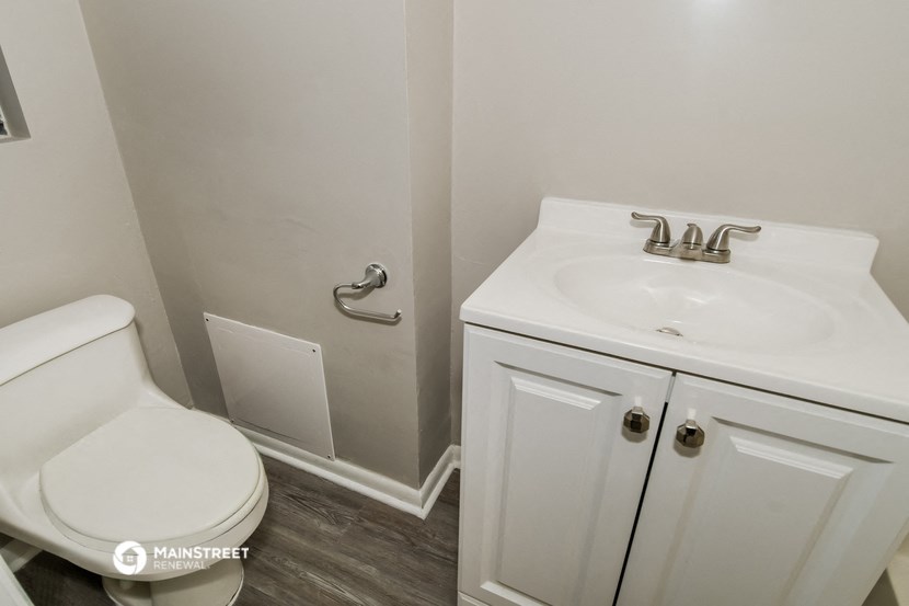 a bathroom with a toilet and a sink and a mirror