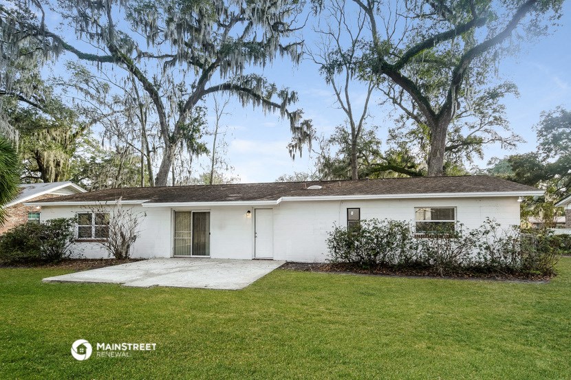 a white house with a lawn and trees