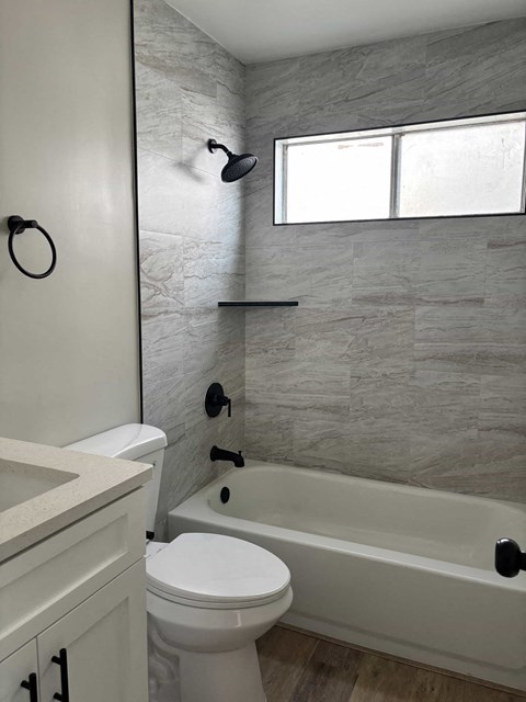A bathroom with a toilet, sink, and tub.