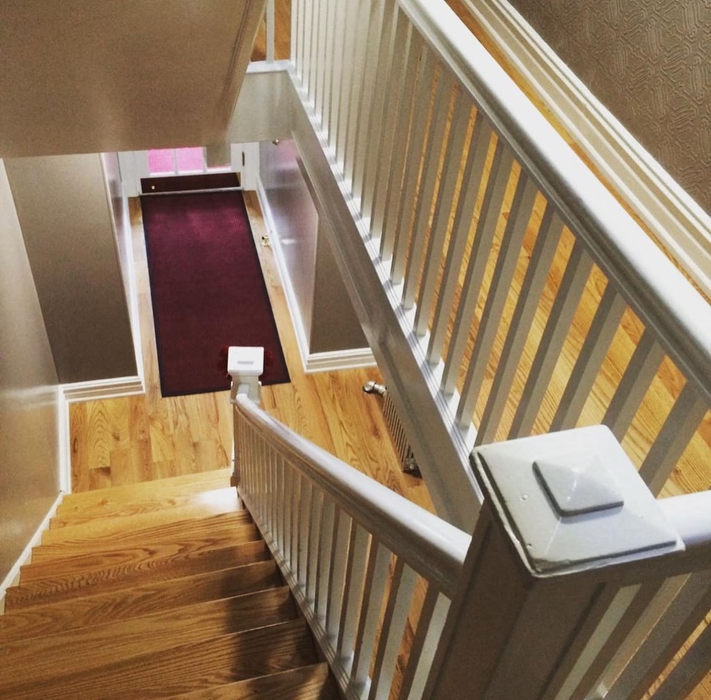 the stairway up to the second floor of a home with a red carpet