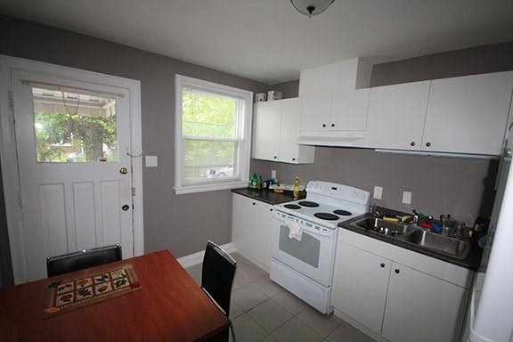 A kitchen with white appliances and a brown table.