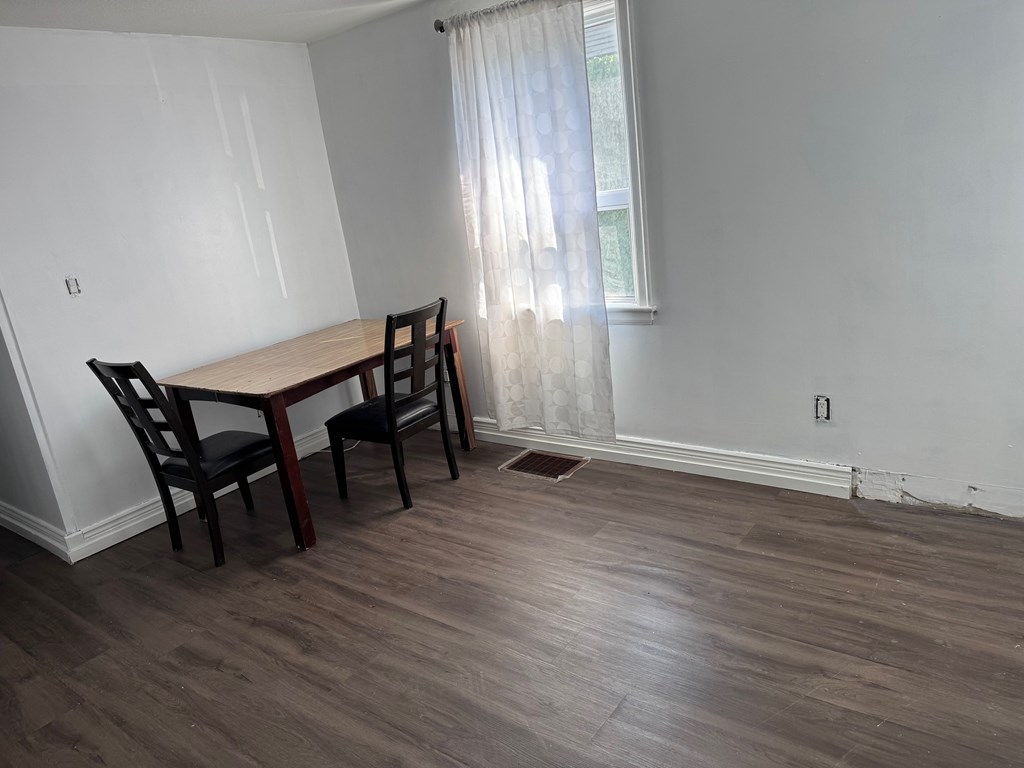 A dining room with a wooden table and chairs.