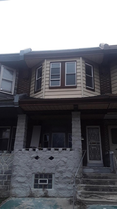 A house with a stone pillar in front of it.