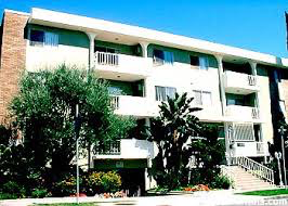 an apartment building with trees in front of it
