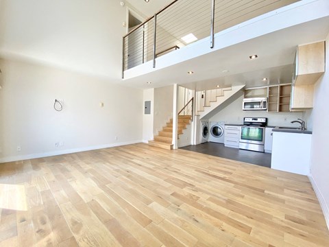 a renovated living room and kitchen with a wood floor