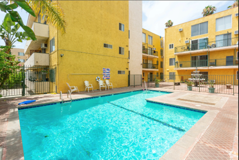 a swimming pool in front of an apartment building