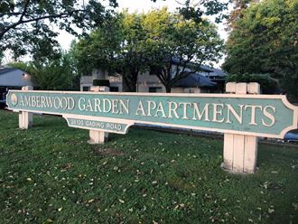 a sign for andreword garden apartments in front of trees