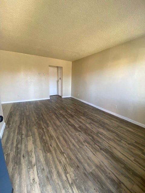 an empty living room with wooden floors and a door