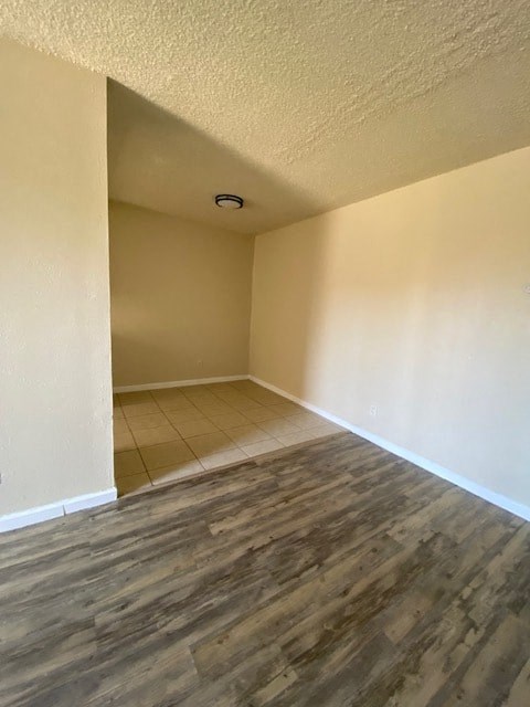 an empty living room with a wood floor and white walls