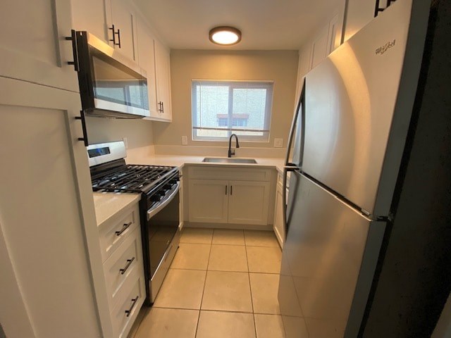 A kitchen with a stove, sink, and refrigerator.