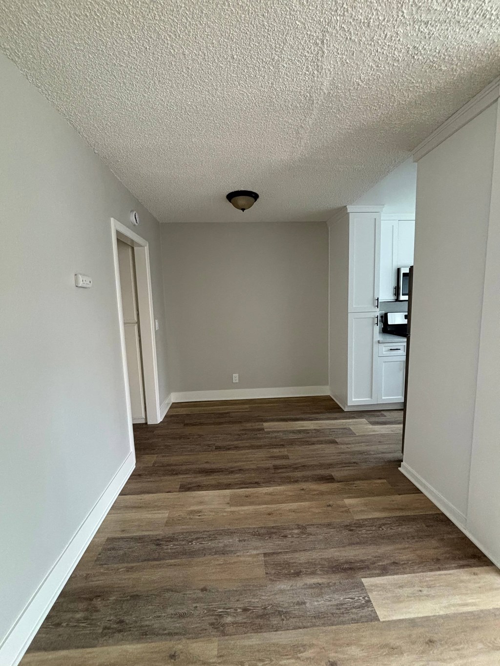 A room with a white ceiling and wooden flooring.