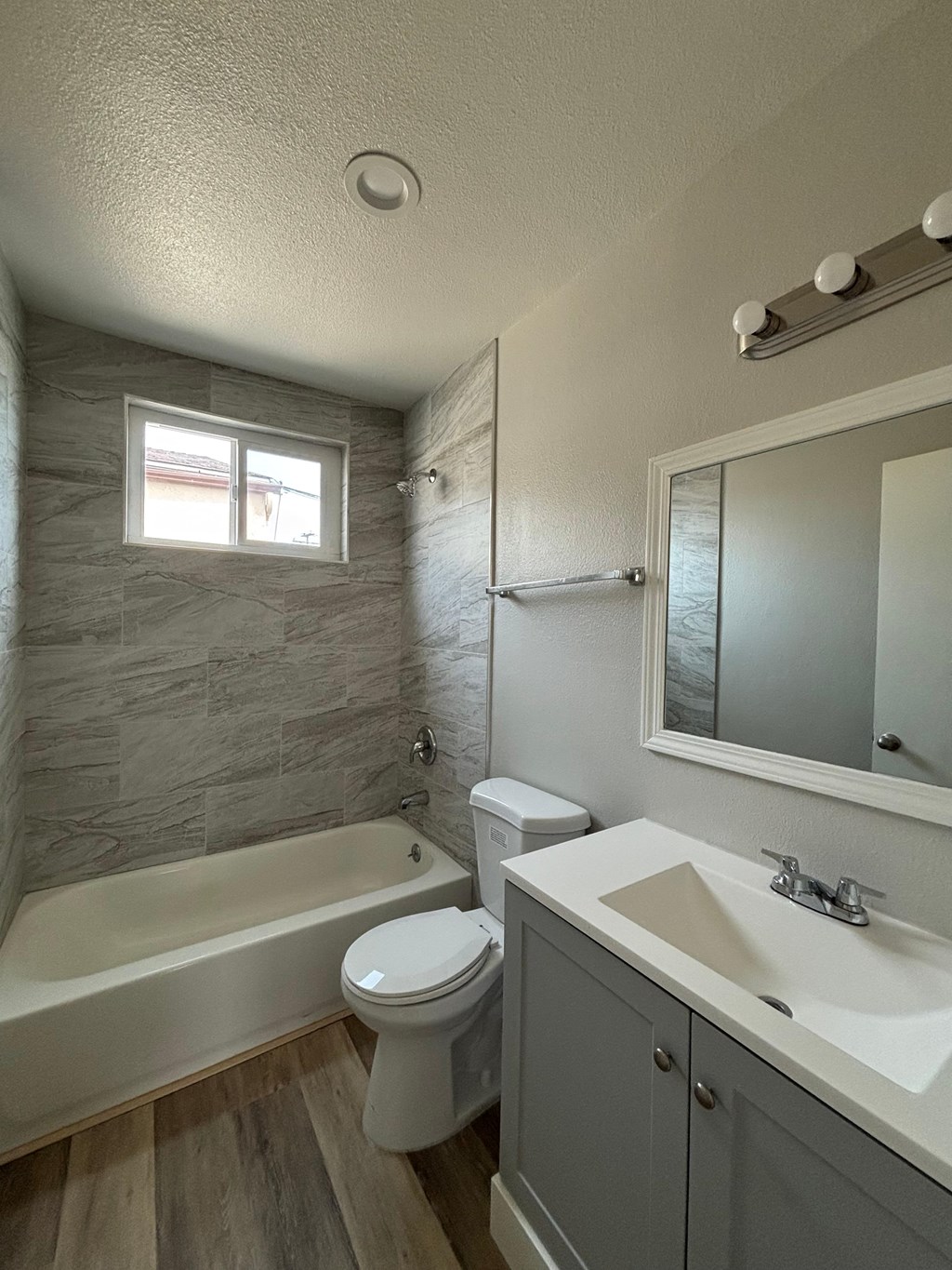 A bathroom with a white toilet, a bathtub, and a sink.