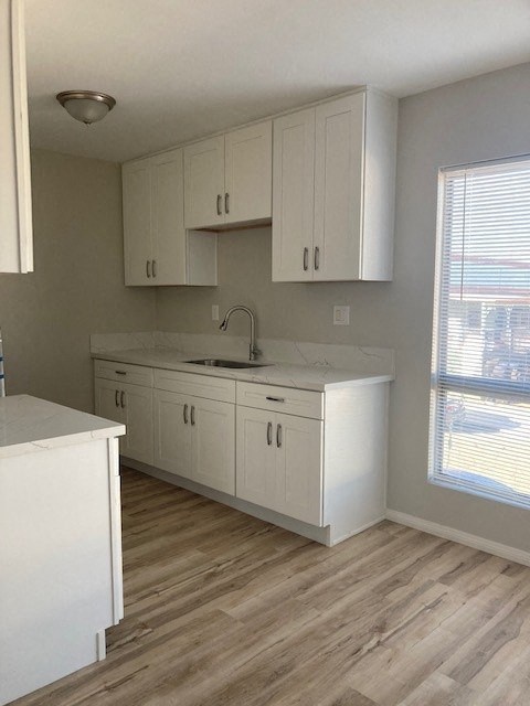 an empty kitchen with white cabinets and a sink