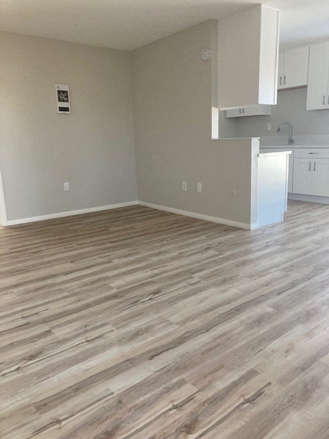 an empty kitchen and living room with wood flooring