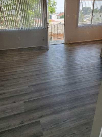a living room with wooden floors and a balcony