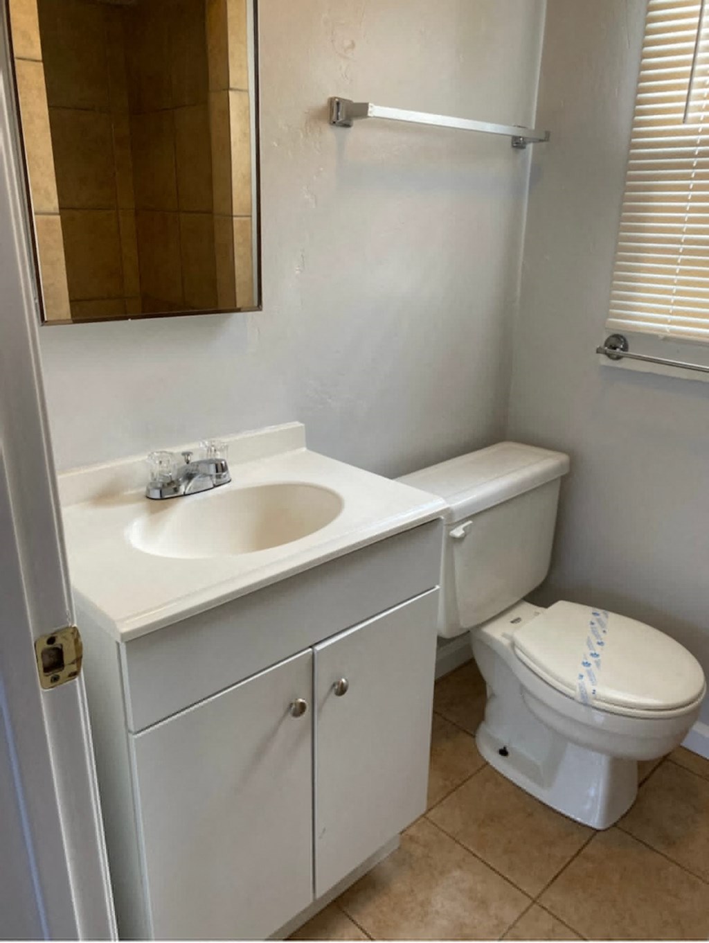 a bathroom with a sink toilet and a mirror