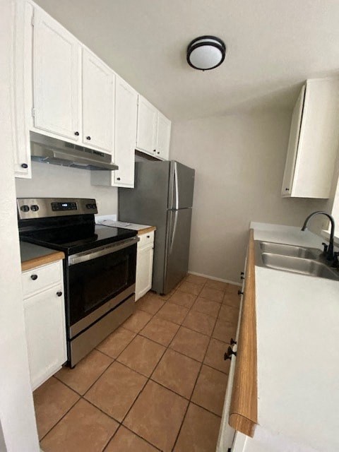a kitchen with white cabinets and a stainless steel refrigerator