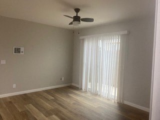 a empty living room with a ceiling fan and a window