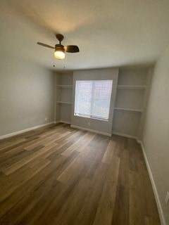 a empty living room with a ceiling fan and a window