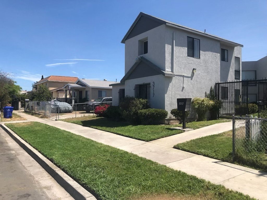 a white house with a yard and a sidewalk