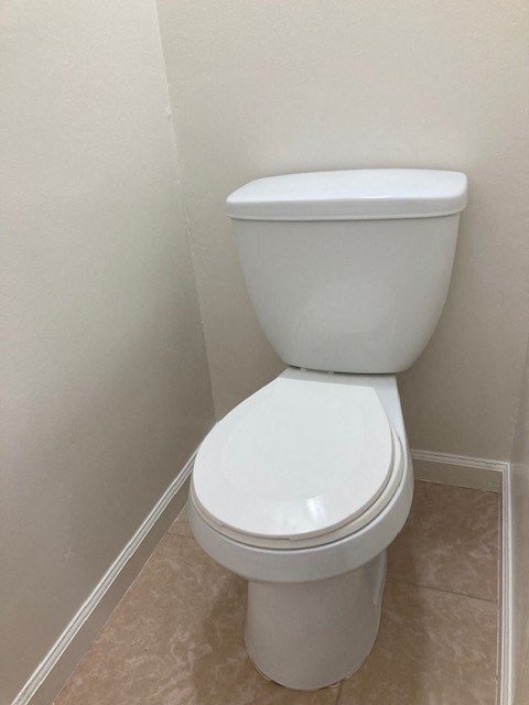 a white toilet in a bathroom with white walls