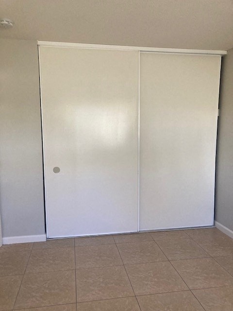 an empty room with white walls and a tiled floor