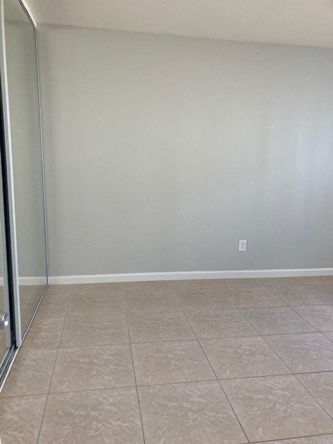 a empty room with a sliding glass door and a tiled floor
