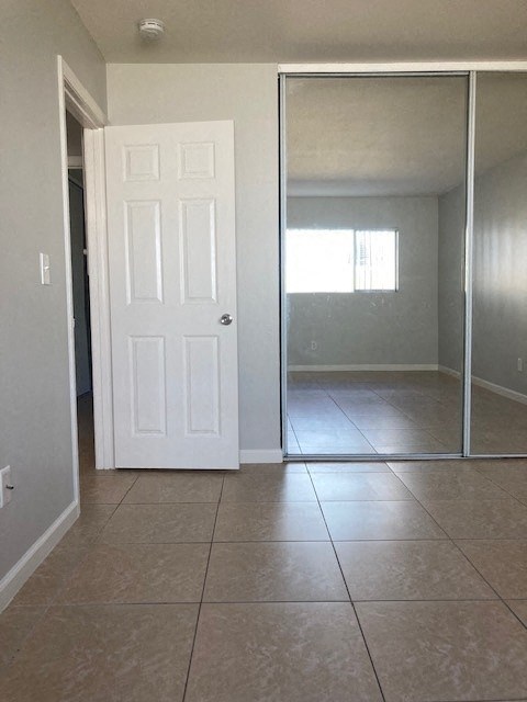 an empty room with a white door and a tiled floor