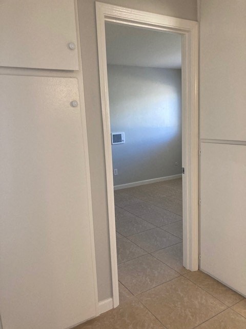 a hallway with a door to a bathroom and a closet