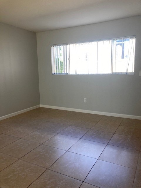 an empty room with a tiled floor and a window