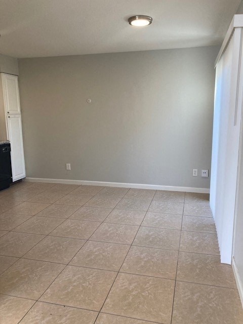 an empty living room with a tiled floor