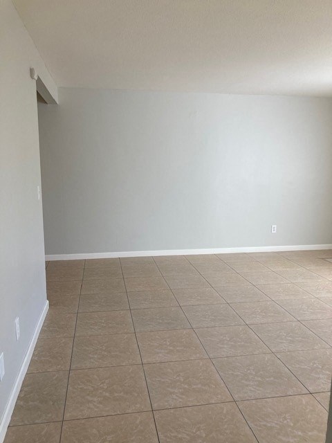 a empty room with a tiled floor and white walls