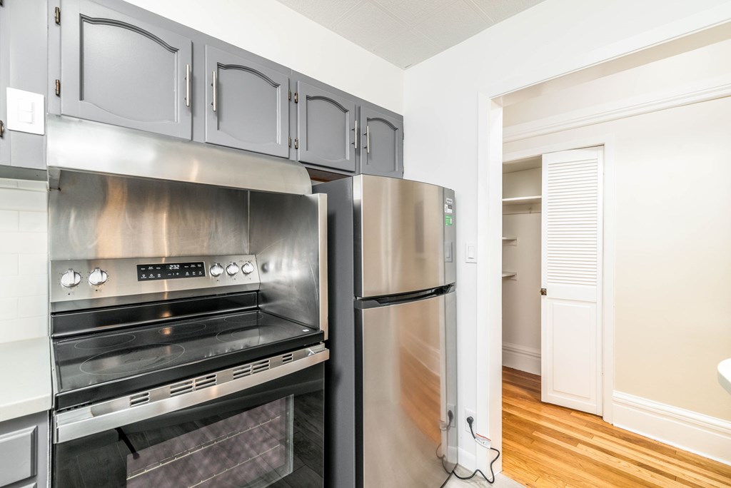A modern kitchen with stainless steel appliances and wooden floors.
