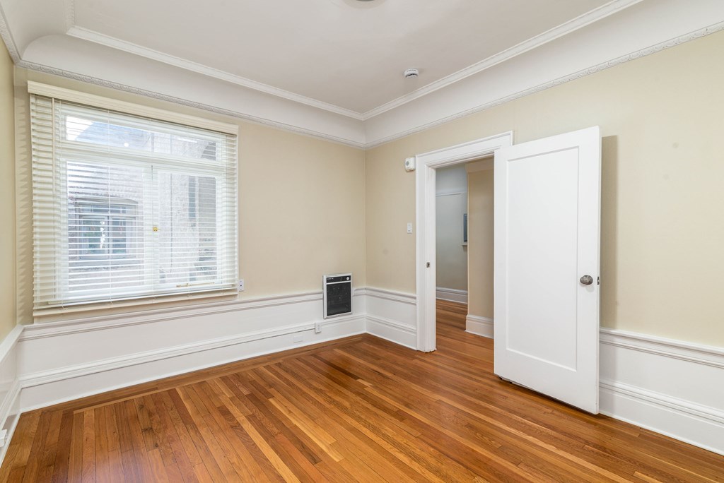 A room with a white door and a window with blinds.