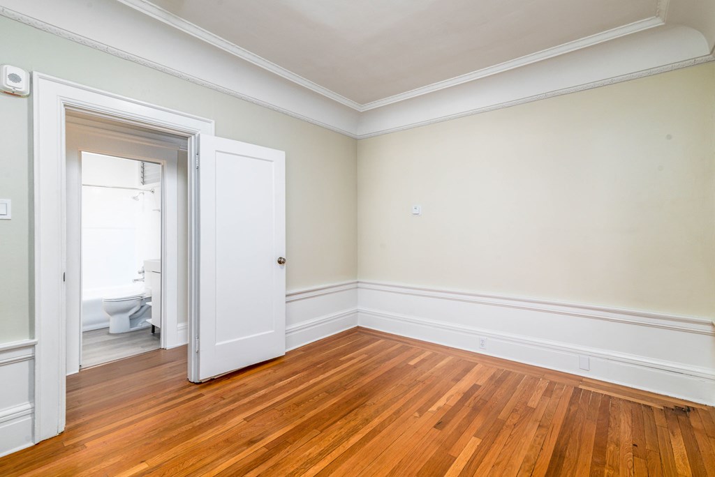 A room with a wooden floor and a white door.