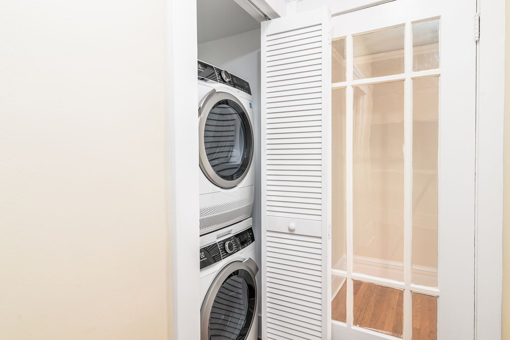 A white washing machine is in a cabinet.