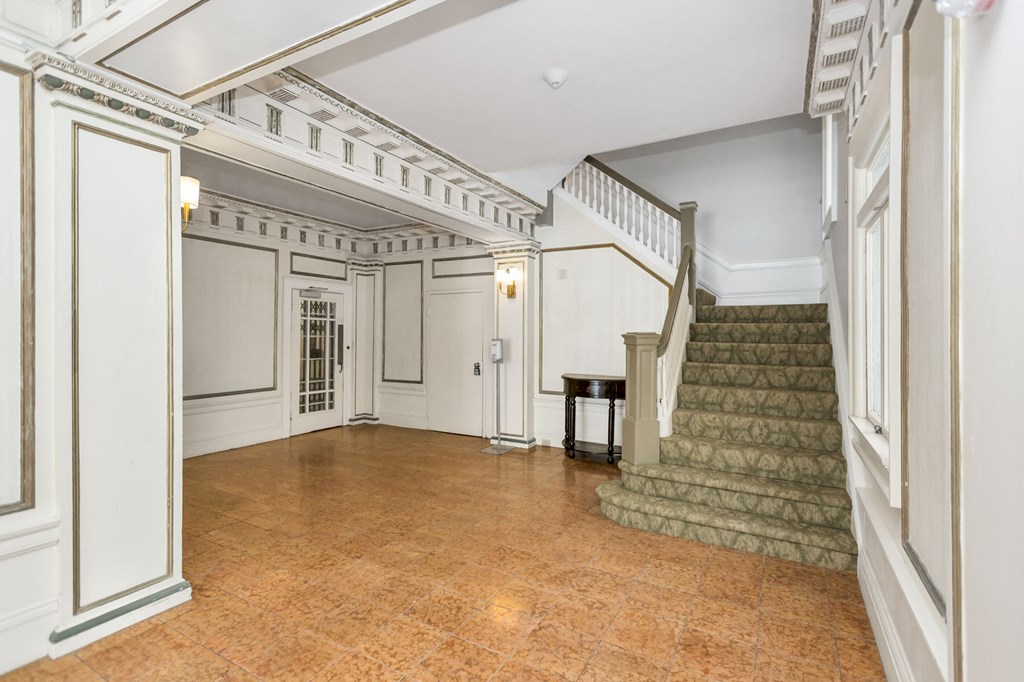 A large, empty room with a staircase and a table.