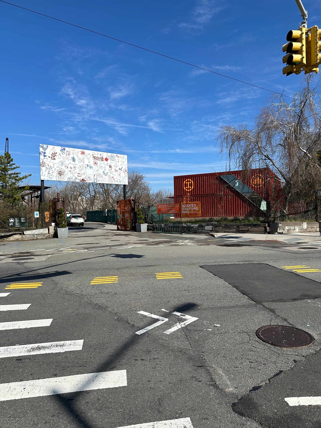 an empty street with a traffic light and a red building