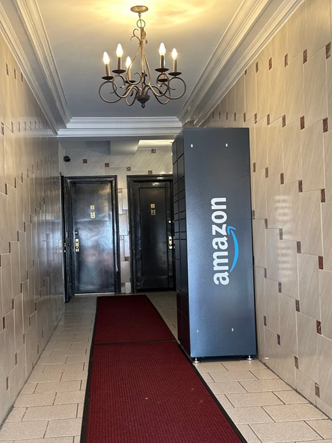 A hallway with a red carpet and a wall with a brick pattern.