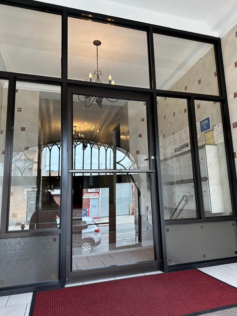 A glass door with a red mat in front of it.