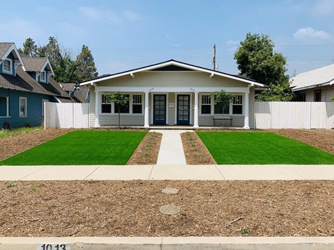 a house with a lawn and a sidewalk in front of it