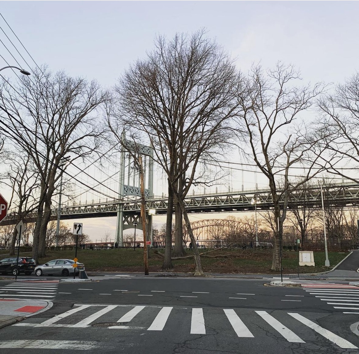 a city street with a suspension bridge in the background