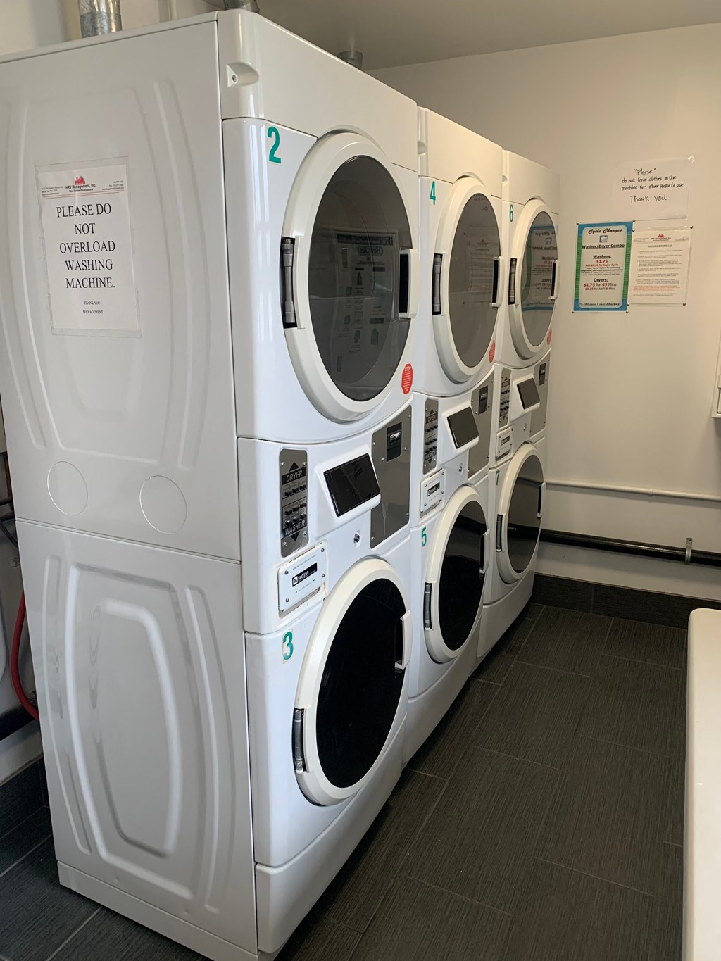 a row of washers and dryers in a laundry room