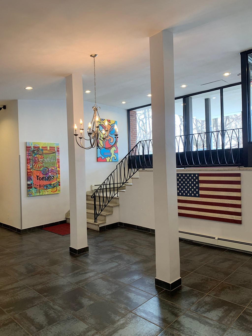 the lobby of a building with a staircase and an flag