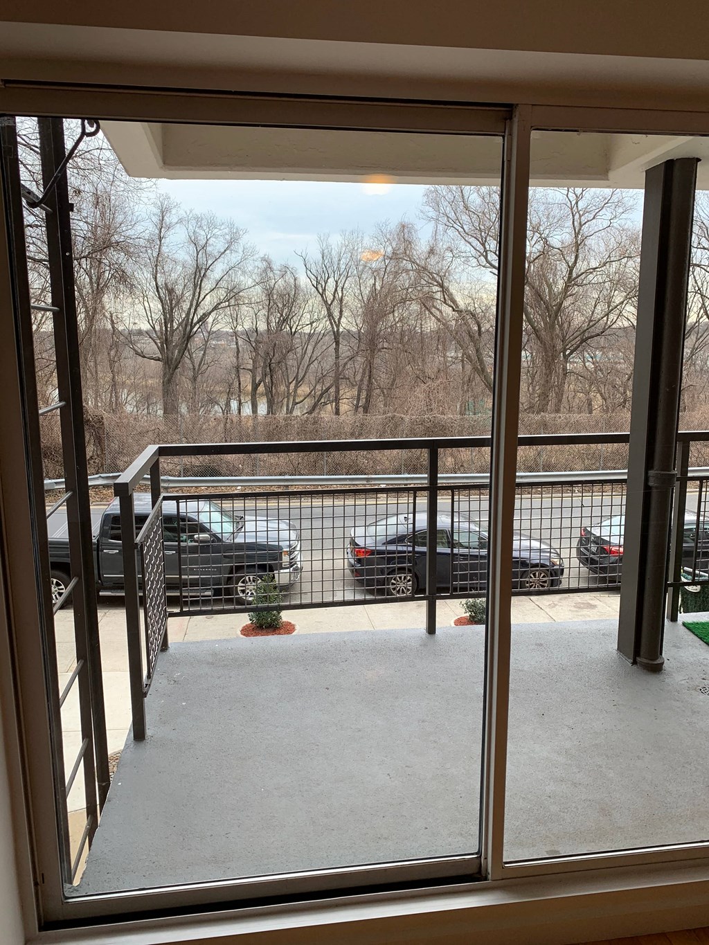 a view of a balcony with cars parked in a parking lot