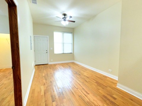 A room with a wooden floor and a ceiling fan.