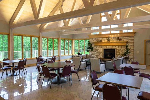a large dining room with tables and chairs and a fireplace