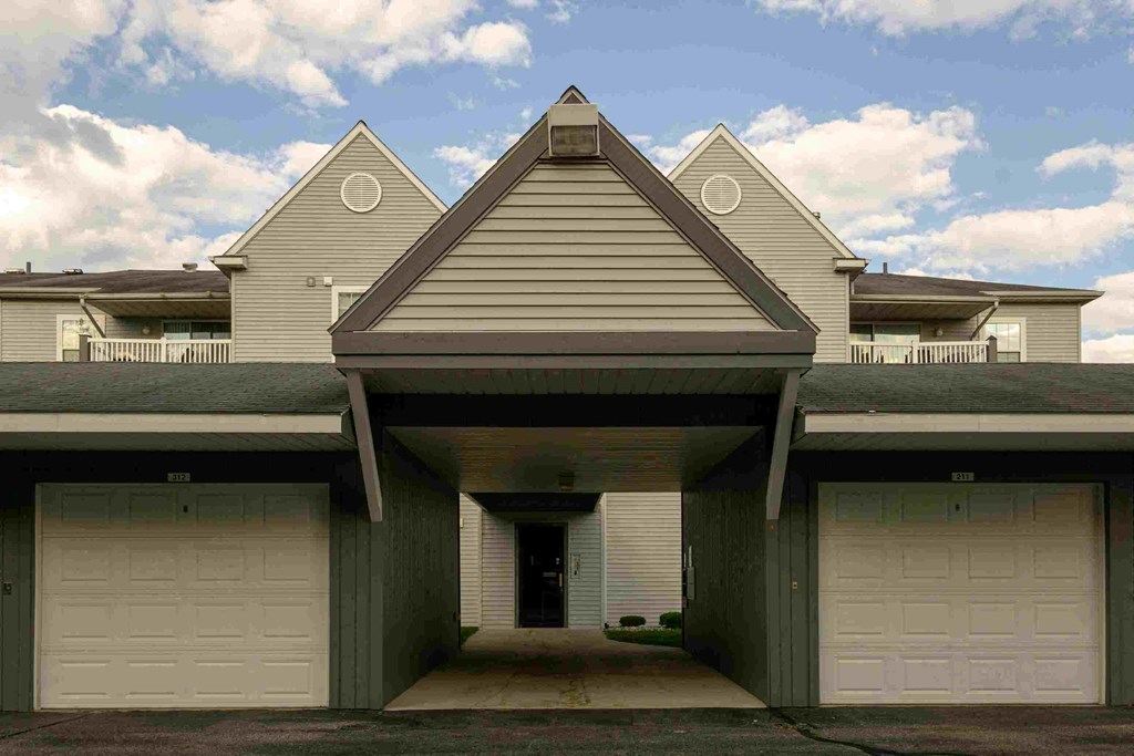 the front of a white house with white garage doors