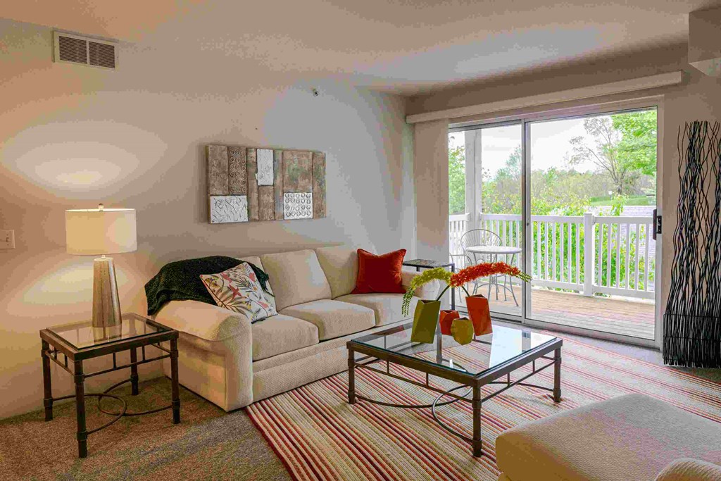 a living room with a couch and a table   and a balcony